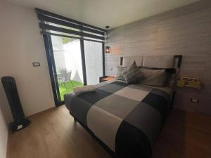1 dormitorio con cama grande y ventana grande en Excelente departamento c/jardín., en Ciudad de México