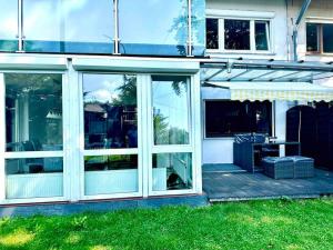 un patio con puertas de cristal y una mesa en una terraza. en Wie Zuhause! Wohnung mit Garten, en Forstinning