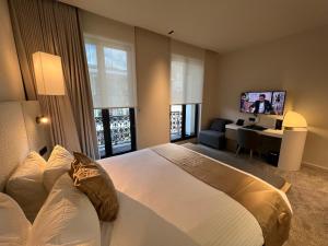 a bedroom with a large white bed and a desk at OPO Hotel in Brussels