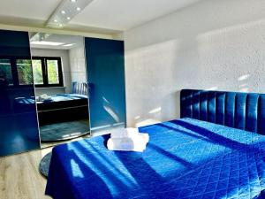 1 dormitorio con cama azul y espejo en Wie Zuhause! Wohnung mit Garten, en Forstinning