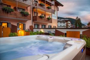安達洛的住宿－Adler Hotel Wellness & Spa - Andalo，热水浴池位于酒店阳台上