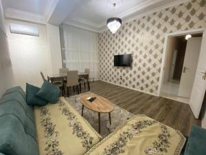 sala de estar con sofá y mesa en Гостевая Квартира, en Sumqayit