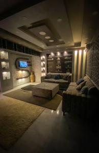 ein Wohnzimmer mit einem Sofa und einem TV in der Unterkunft فيلا جراند ماجيك الفندقيه in Kairo