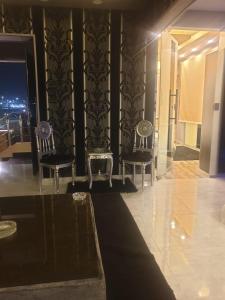 eine Lobby mit zwei Stühlen und einem TV in einem Gebäude in der Unterkunft فيلا جراند ماجيك الفندقيه in Kairo