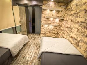 1 Schlafzimmer mit 2 Betten und einer Steinmauer in der Unterkunft فيلا جراند ماجيك الفندقيه in Kairo