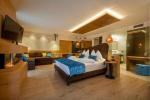 a bedroom with a bed and a living room at Adler Hotel Wellness & Spa - Andalo in Andalo