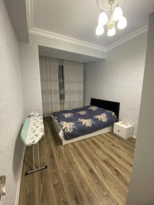 Un dormitorio con una cama y una mesa. en Гостевая Квартира, en Sumqayit