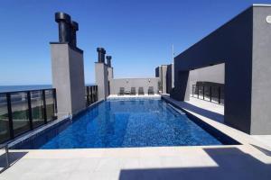 a swimming pool on the roof of a building at Studio 105 Maravilhoso Frente Mar Piscina Aquecida in Matinhos
