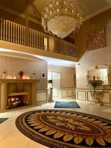 a large living room with a chandelier and a large rug at FINN VILLAGE - Loch Lomond Villa B&B with a Hot Tub in Glasgow