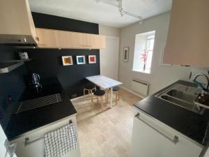 a kitchen with black counter tops and a sink at Lombard Hide Away in Inverness