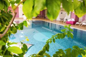 a swimming pool in a house with green plants at Yes Hotel Touring & SPA in Rimini