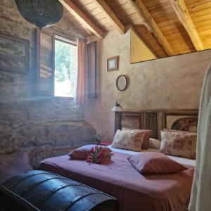 Un dormitorio con una cama con sábanas moradas y una ventana en El Racó dels Mussols 2, en Adri