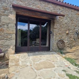 una puerta a un edificio de piedra con una ventana en El Racó dels Mussols 2, en Adri