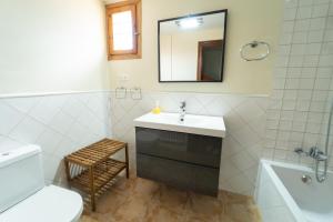 a bathroom with a sink and a toilet and a mirror at VUT CASA ADOBAS in Montalbán