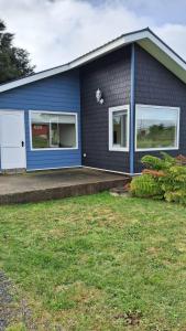 Casa azul con ventanas blancas y patio en Cabañas Puerto Varas, en Puerto Varas