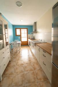 a kitchen with white cabinets and a tile floor at VUT CASA ADOBAS in Montalbán