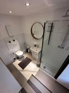 uma casa de banho com um chuveiro, um WC e um lavatório. em Orient Apartment nähe Autobahn A57 em Krefeld