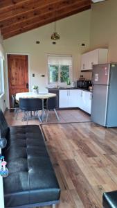 a kitchen with a table and a refrigerator at Cabañas Puerto Varas in Puerto Varas