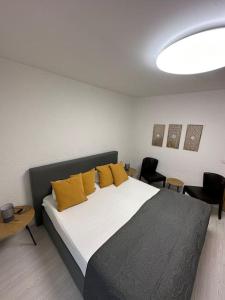 1 dormitorio con 1 cama grande con almohadas amarillas en Orient Apartment nähe Autobahn A57, en Krefeld