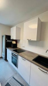 uma cozinha com armários brancos e um forno com placa de fogão em Orient Apartment nähe Autobahn A57 em Krefeld