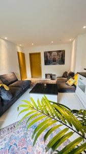 a living room with two couches and a palm tree at Orient Apartment nähe Autobahn A57 in Krefeld