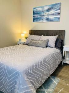 1 dormitorio con 1 cama grande y edredón blanco en Pensa-Cozy Downtown bungalow, w/ backyard oasis! en Pensacola