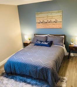 1 dormitorio con 1 cama con edredón azul y 2 mesas en Pensa-Cozy Downtown bungalow, w/ backyard oasis! en Pensacola