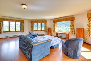1 Schlafzimmer mit einem Bett, 2 Stühlen und Fenstern in der Unterkunft Wyoming Retreat on Wood River Hike and Fly Fish! in Meeteetse