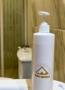 a white water bottle sitting on a table with a toilet at Pyramids Glory Inn in Cairo +51 photos