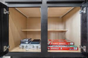 einem Schrank mit Büchern und anderen Artikeln in der Unterkunft Houston Home Nr Iah Games Wi-fi Bbq Yard in Houston
