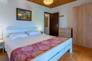 ein Schlafzimmer mit einem großen Bett und einer Holztür in der Unterkunft Apartment Lumanera Stivan in Štivan