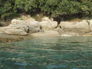 a body of water next to some rocks at Apartment Lumanera Stivan in Štivan