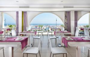 a restaurant with tables and chairs with a view at Yes Hotel Touring & SPA in Rimini
