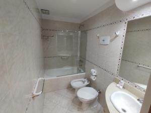 uma casa de banho com um WC, um chuveiro e um lavatório. em Goya Hotel em Buenos Aires