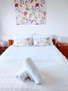 - un lit blanc avec une serviette enroulée dans l'établissement Toppers Bright Seaview Family or Couple Home Devon Westward Ho!, à Bideford