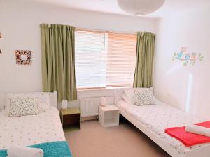 - une chambre avec 2 lits et une fenêtre dans l'établissement Toppers Bright Seaview Family or Couple Home Devon Westward Ho!, à Bideford