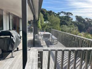 a deck with a table and chairs on a house at Waikawa Bay bach with spectacular views in Waikawa