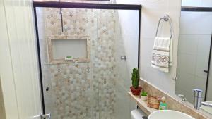 W łazience znajduje się prysznic ze szklanymi drzwiami. w obiekcie Flat da Eliete e Admilson w mieście Porto Seguro