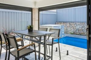 a patio with a table and chairs and a swimming pool at Rengor Executive Retreat in Belmont