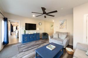 uma sala de estar com um sofá e uma ventoinha de tecto em SunKissed em Bay St. Louis