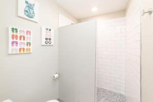 La salle de bains blanche est pourvue d'une douche et de toilettes. dans l'établissement SunKissed, à Bay Saint Louis
