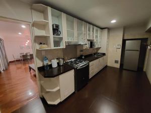 Una cocina con gabinetes blancos y una encimera negra. en MLA apartments - Bolognesi, en Lima