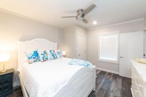 um quarto com uma cama branca e almofadas azuis em SunKissed em Bay St. Louis