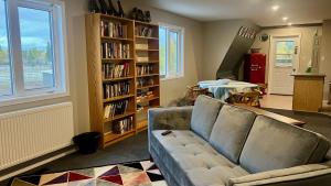 a living room with a couch and a book shelf at The Big Red Barn in Whitehorse