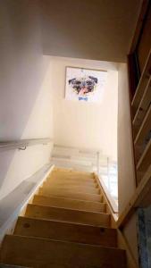 una escalera en una habitación con una pintura en la pared en Location duplex tout confort, en Erquinghem-Lys