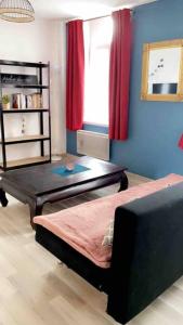a living room with a bed and a tv in it at Location duplex tout confort in Erquinghem-Lys