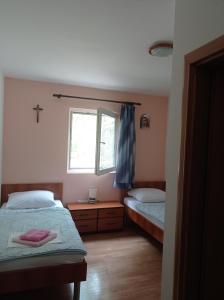 una camera con 2 letti singoli e una finestra di Casa Del Pellegrino M&A - Ostojići a Međugorje