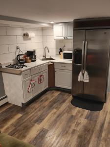 eine Küche mit einem Kühlschrank aus Edelstahl und Holzböden in der Unterkunft JD COZYNEST LLC in Shirley