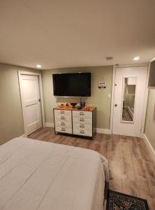 Schlafzimmer mit einem Bett und einem Flachbild-TV in der Unterkunft JD COZYNEST LLC in Shirley