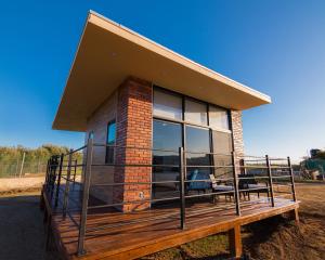 a house with a large deck with windows at Cabaña en el Valle in Ensenada